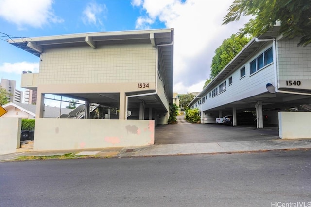 view of property exterior featuring covered parking