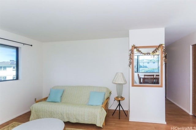 living area with baseboards and wood finished floors