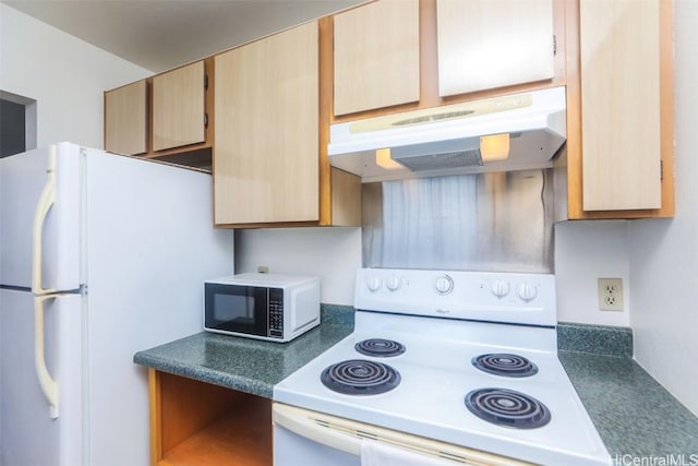 kitchen featuring white appliances, dark countertops, light brown cabinets, and under cabinet range hood