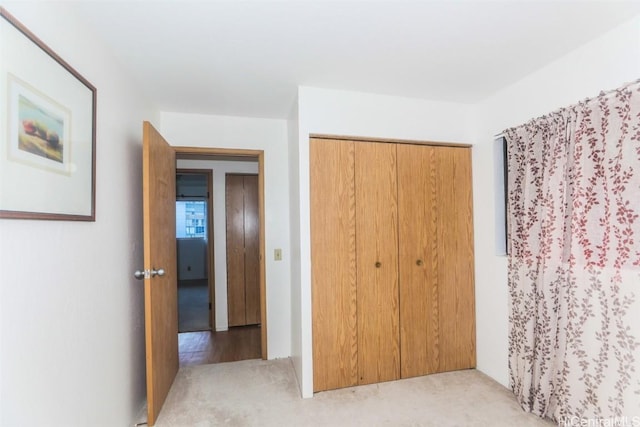 unfurnished bedroom with a closet and light carpet