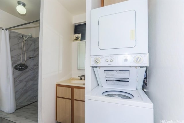 clothes washing area featuring stacked washer / dryer, laundry area, and a sink