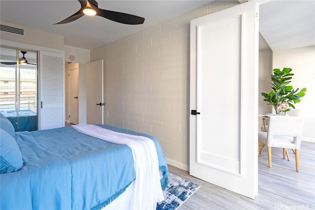 bedroom with ceiling fan, wood finished floors, visible vents, and baseboards