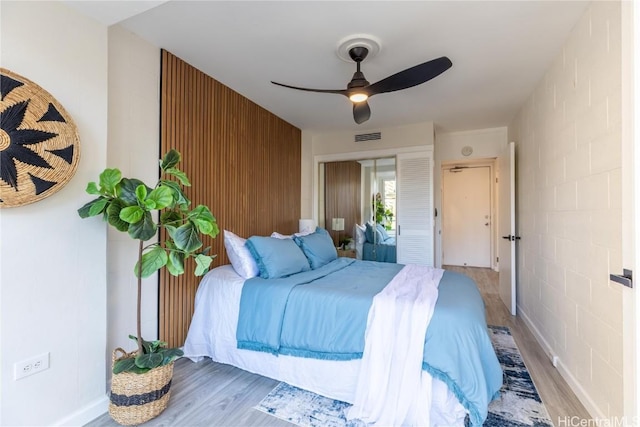 bedroom with a ceiling fan, a closet, visible vents, and wood finished floors