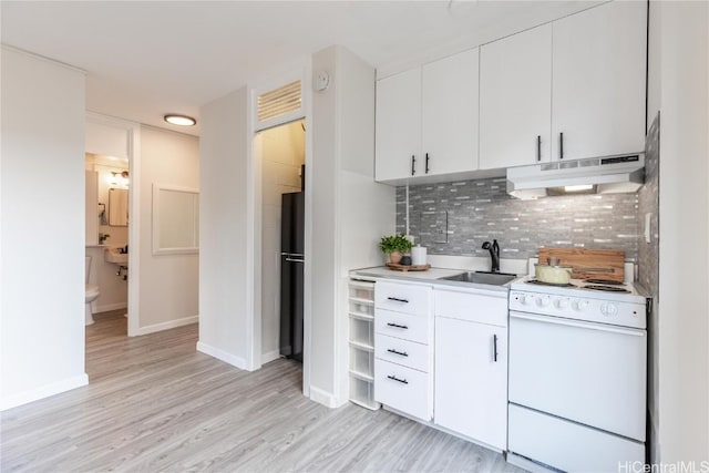 kitchen with white electric range, backsplash, freestanding refrigerator, a sink, and under cabinet range hood