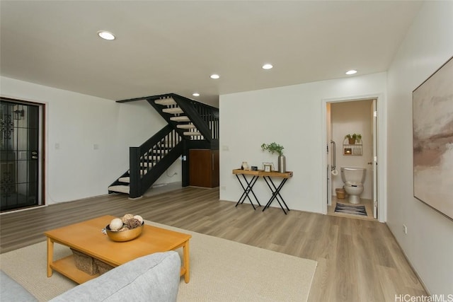 living area with stairs, wood finished floors, and recessed lighting