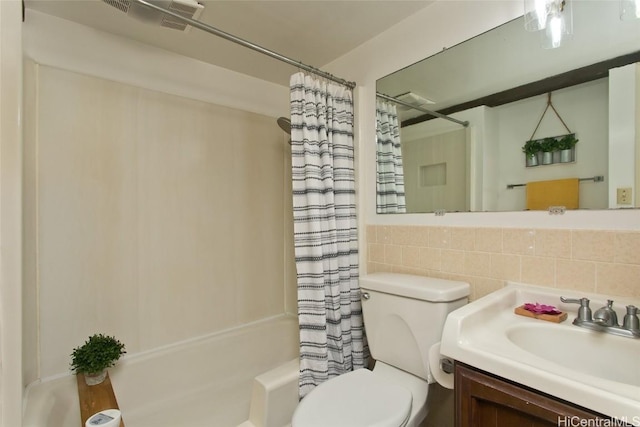 bathroom with toilet, tile walls, shower / tub combo with curtain, and vanity