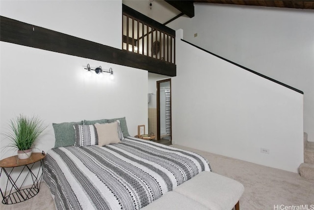 carpeted bedroom with high vaulted ceiling and beam ceiling