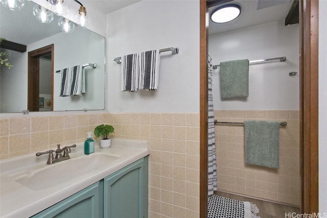 bathroom featuring wainscoting, vanity, and tile walls