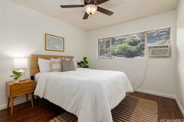 bedroom with cooling unit, baseboards, wood finished floors, and a ceiling fan