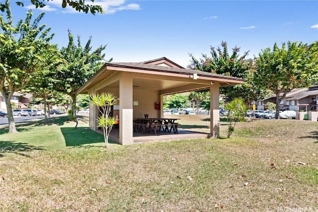 view of property's community featuring a yard and a patio