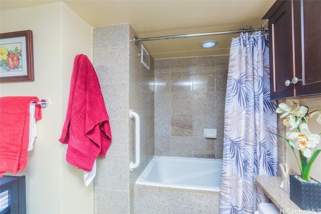 full bathroom with tiled shower / bath combo and visible vents