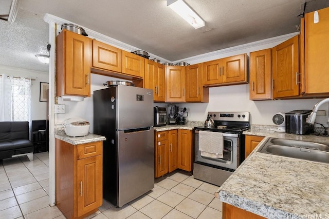 kitchen featuring light countertops, brown cabinets, appliances with stainless steel finishes, a textured ceiling, and a sink