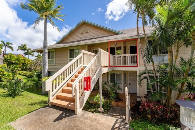 coastal home with a front lawn and stairway