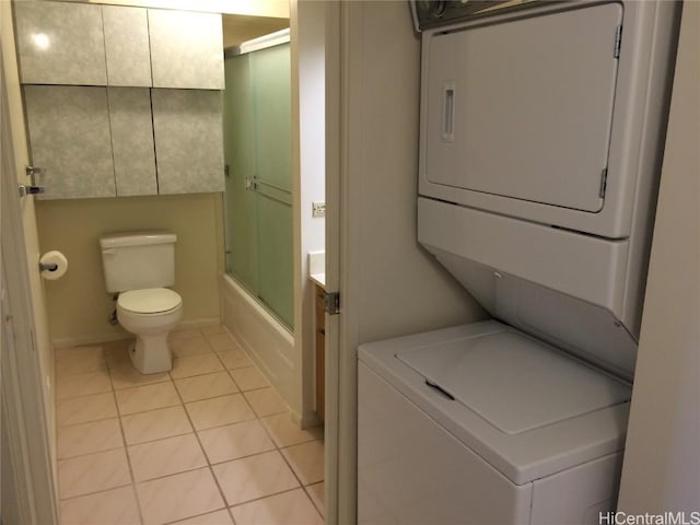 laundry area featuring laundry area, stacked washer and dryer, and light tile patterned flooring
