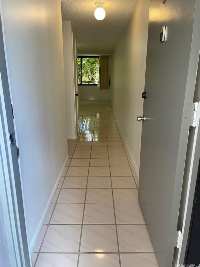 825 Coolidge St Unit 311, Honolulu, HI 96826 - corridor featuring light tile patterned floors, a textured ceiling, and baseboards