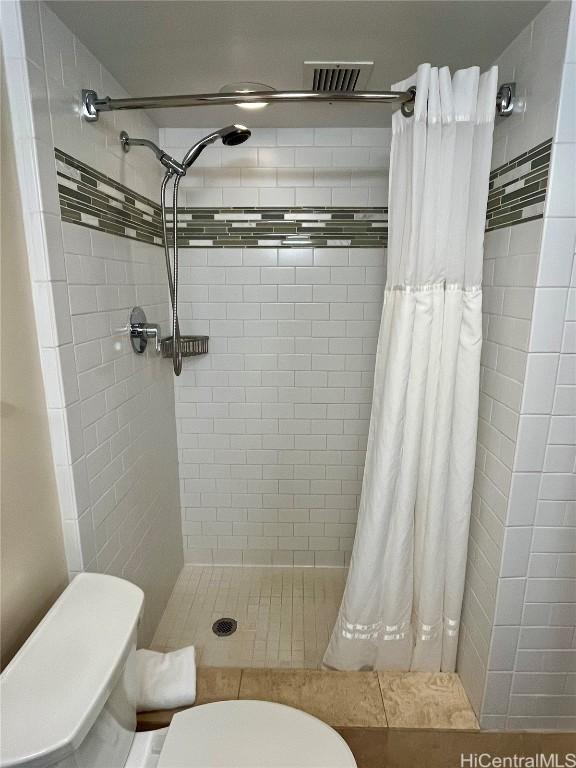 bathroom featuring visible vents, a shower stall, and toilet