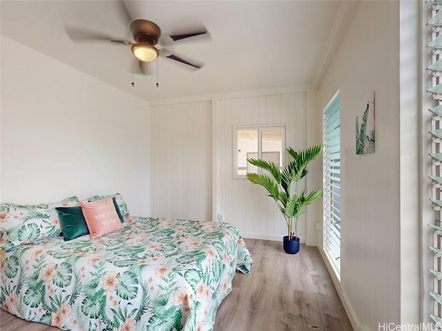 bedroom with ceiling fan, wood finished floors, and baseboards