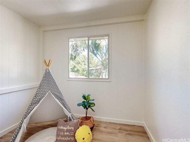 recreation room with baseboards and wood finished floors