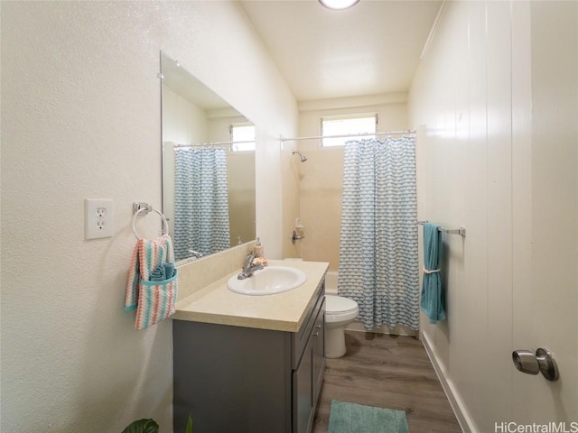 full bathroom with a shower with shower curtain, vanity, toilet, and wood finished floors