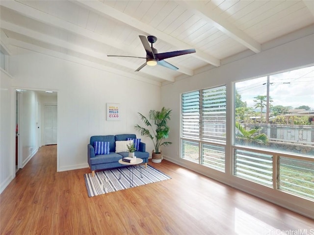 living area with lofted ceiling with beams, baseboards, a ceiling fan, and wood finished floors