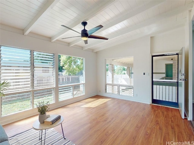 unfurnished living room featuring vaulted ceiling with beams, ceiling fan, wood finished floors, wooden ceiling, and baseboards