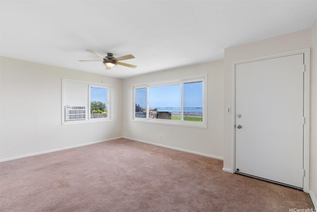 carpeted spare room with baseboards and a ceiling fan