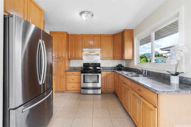 kitchen featuring a sink, stainless steel appliances, under cabinet range hood, and light tile patterned floors