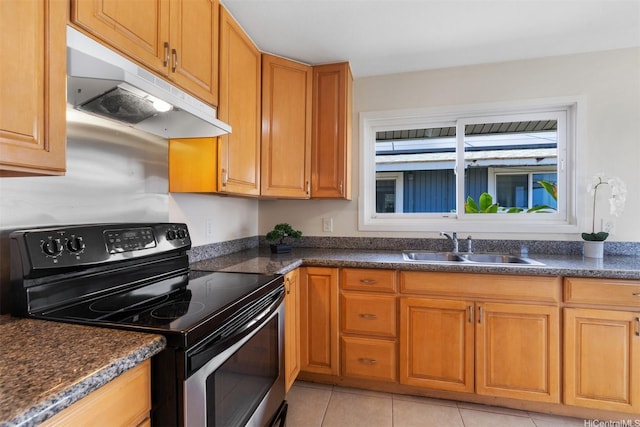 kitchen with stainless steel range with electric stovetop, light tile patterned floors, a sink, dark countertops, and under cabinet range hood