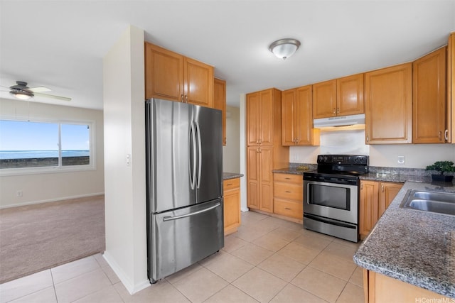 kitchen with light tile patterned floors, a ceiling fan, stainless steel appliances, under cabinet range hood, and light carpet