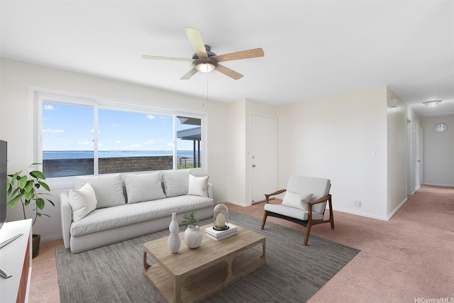 living area featuring baseboards, ceiling fan, and carpet floors