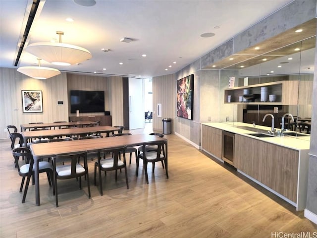 dining area with beverage cooler, recessed lighting, and light wood-style floors