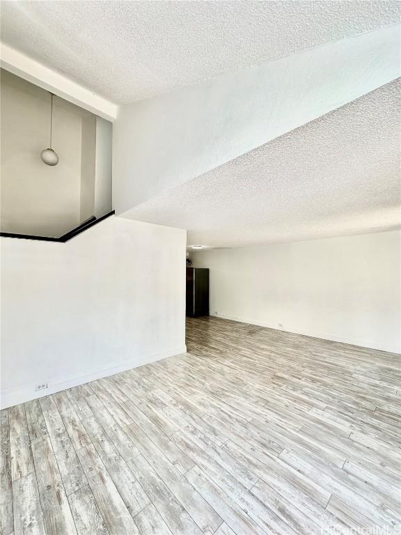 interior space with a textured ceiling and wood finished floors