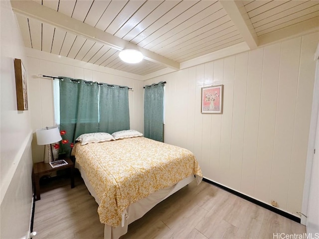 bedroom featuring light wood-type flooring, wooden ceiling, and beam ceiling