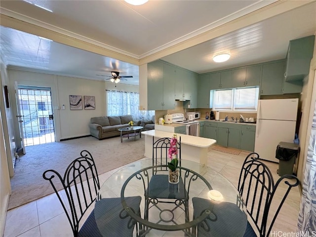 dining area featuring ornamental molding, light colored carpet, ceiling fan, and light tile patterned floors