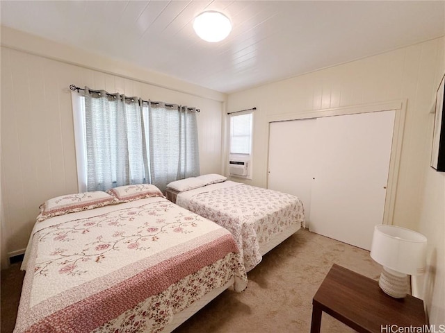 bedroom featuring a closet, cooling unit, visible vents, and light colored carpet