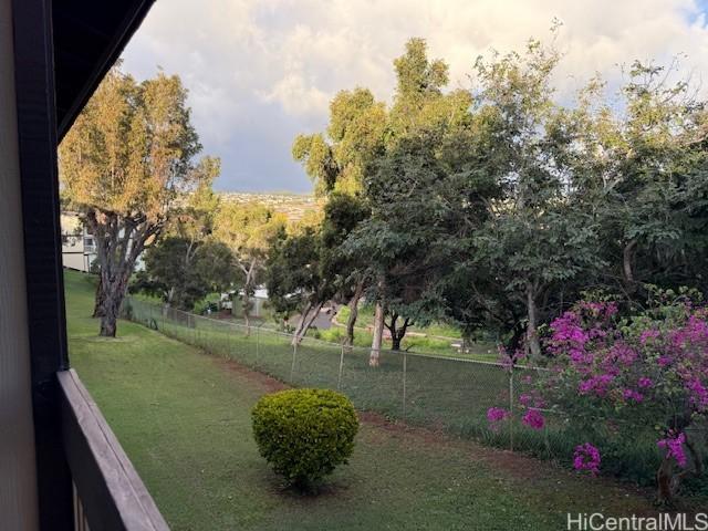 view of property's community with a lawn and fence