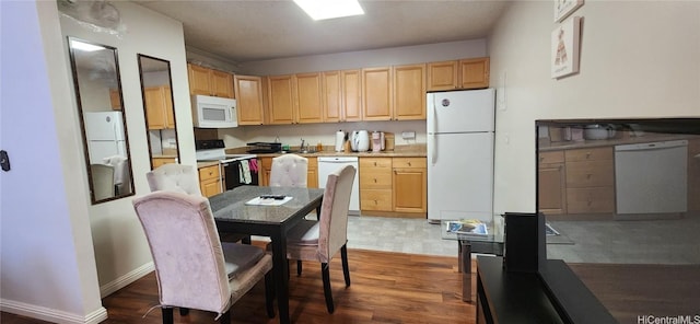 kitchen featuring dark wood-style flooring, light countertops, light brown cabinets, white appliances, and baseboards