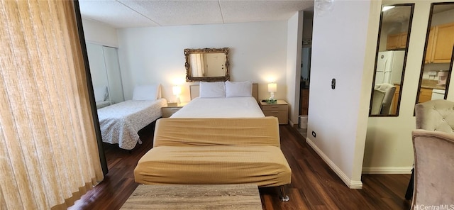 bedroom with a textured ceiling, wood finished floors, and baseboards