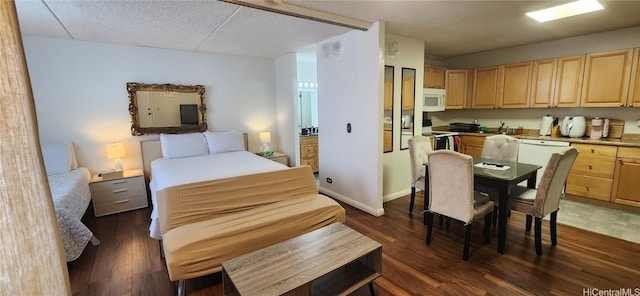 bedroom with dark wood-type flooring, a textured ceiling, and baseboards