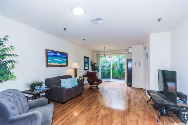 living room with visible vents and light wood-style flooring