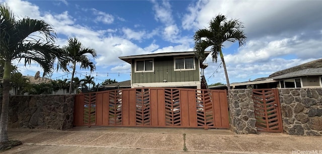 view of front of home with board and batten siding, a gate, and fence