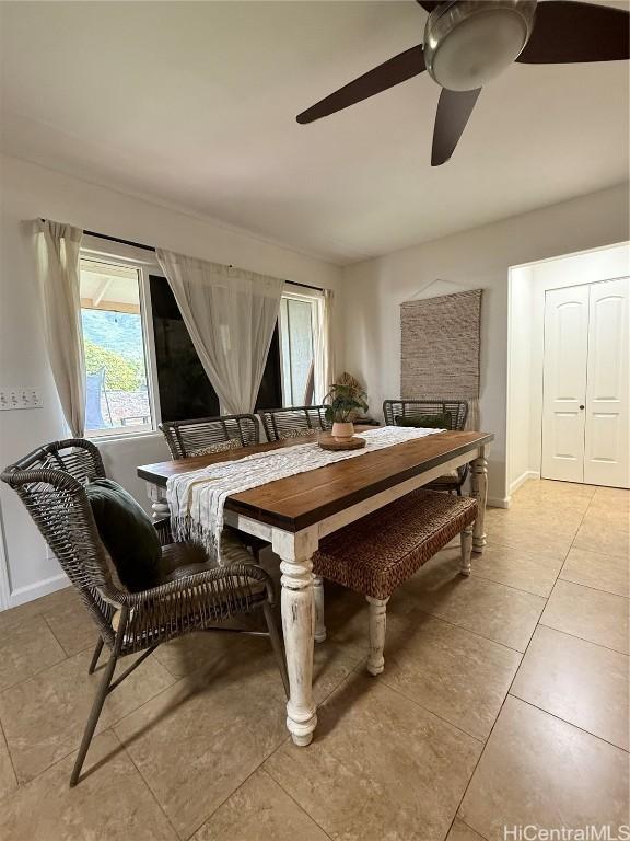 dining space featuring light tile patterned flooring, a ceiling fan, and baseboards