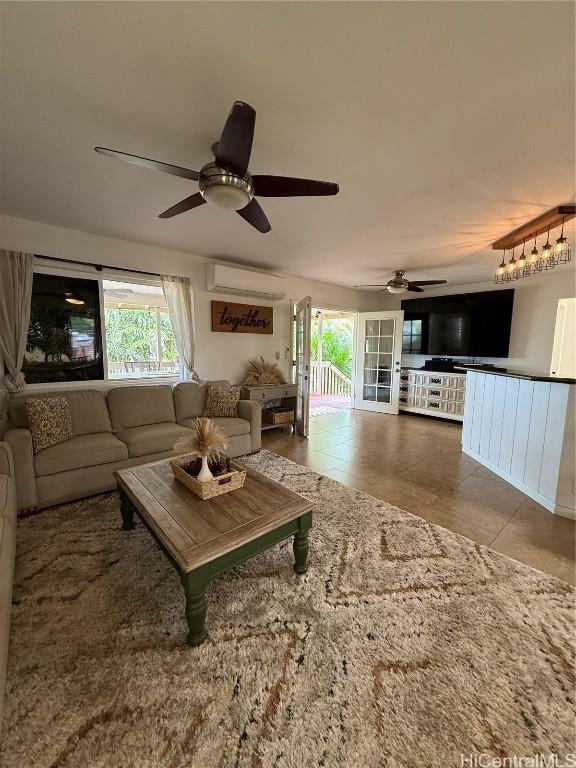 tiled living area with a wealth of natural light, a wall unit AC, and ceiling fan