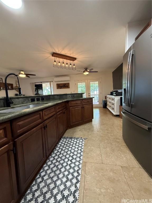 kitchen featuring ceiling fan, a sink, a wall mounted AC, dark countertops, and stainless steel fridge