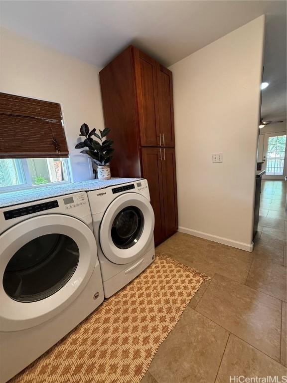 laundry room featuring washer and dryer, cabinet space, baseboards, and light tile patterned floors