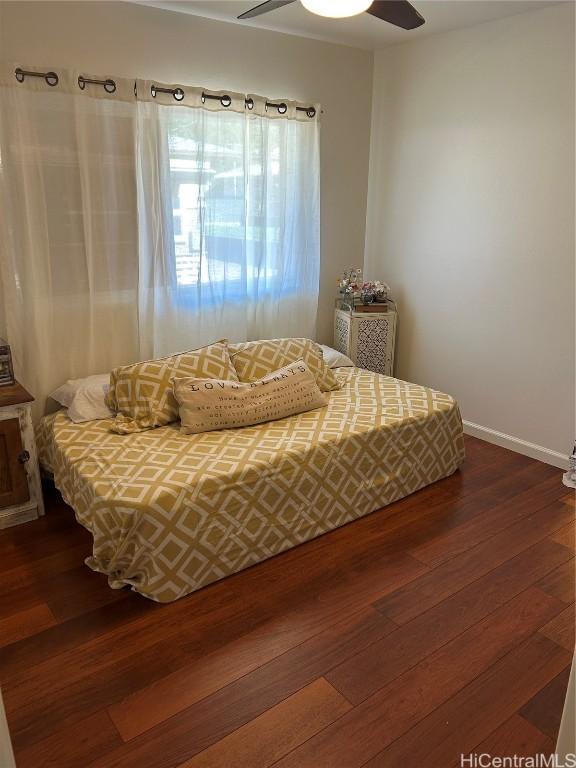 bedroom with wood-type flooring and baseboards