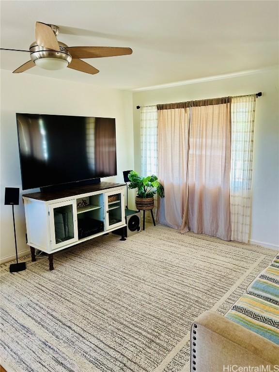 living room with a wealth of natural light, carpet flooring, and ceiling fan