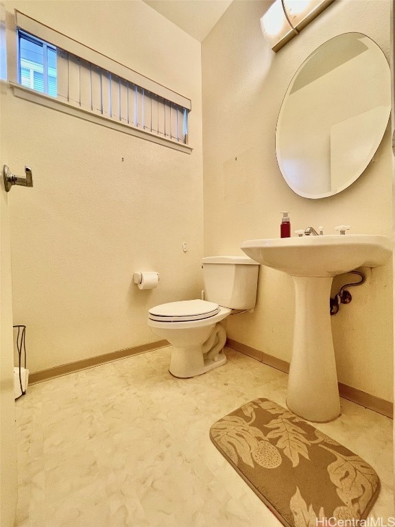 half bathroom with toilet and baseboards