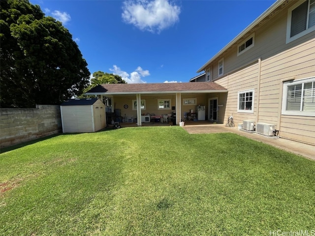 back of property with an outbuilding, a yard, central air condition unit, a patio area, and a shed