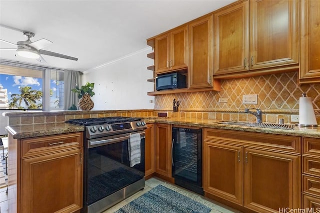 kitchen with stainless steel gas range oven, decorative backsplash, wine cooler, black microwave, and a sink